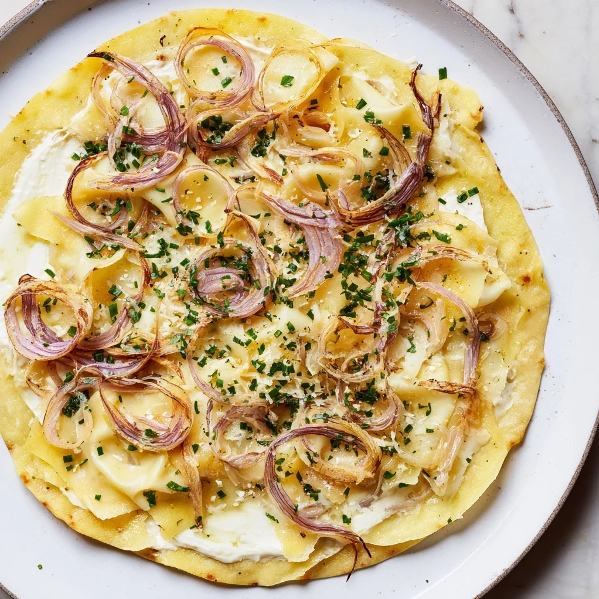 This homemade Savory Maultaschen flatbread offers a close-up view of fresh herbs and bubbling, melted Emmental.