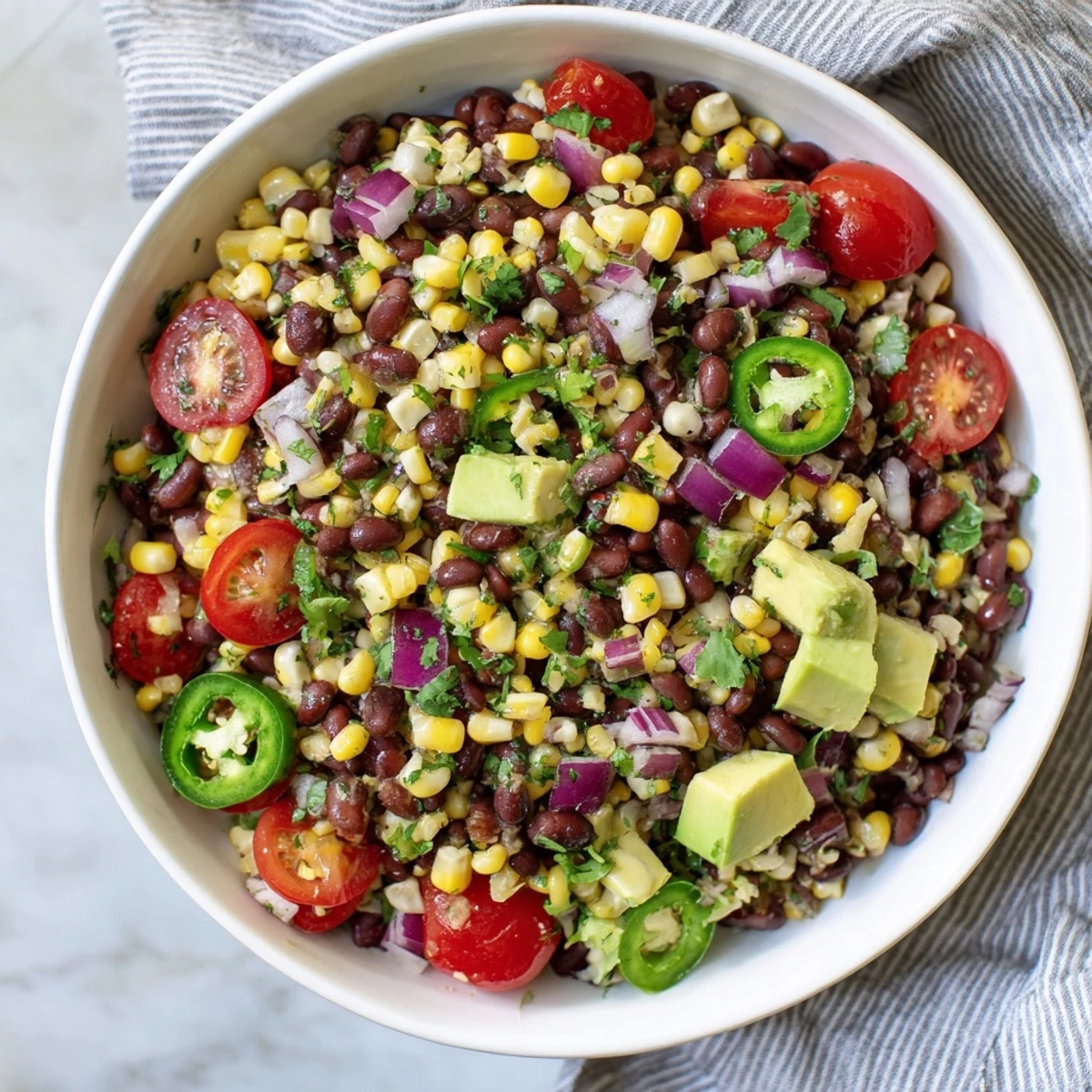 Saftiger Southwestern Black Bean and Corn Salad, abgebildet mit farbenfrohen Gemüse und einem frischen Limetten-Dressing.