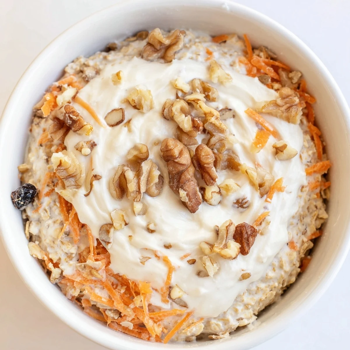 Creamy carrot cake overnight oats, layered with grated carrots and crunchy walnuts, ready to eat.