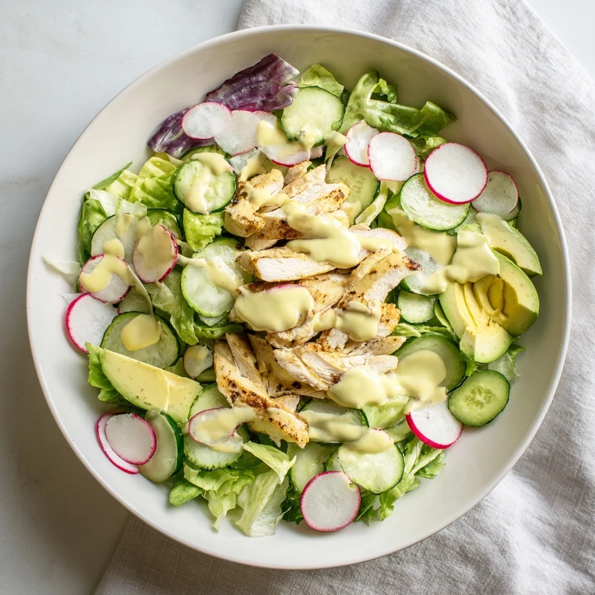 A hearty slice of Spring Detox Chicken Salad, showing mixed greens, cucumber, and grilled chicken with lemon vinaigrette.