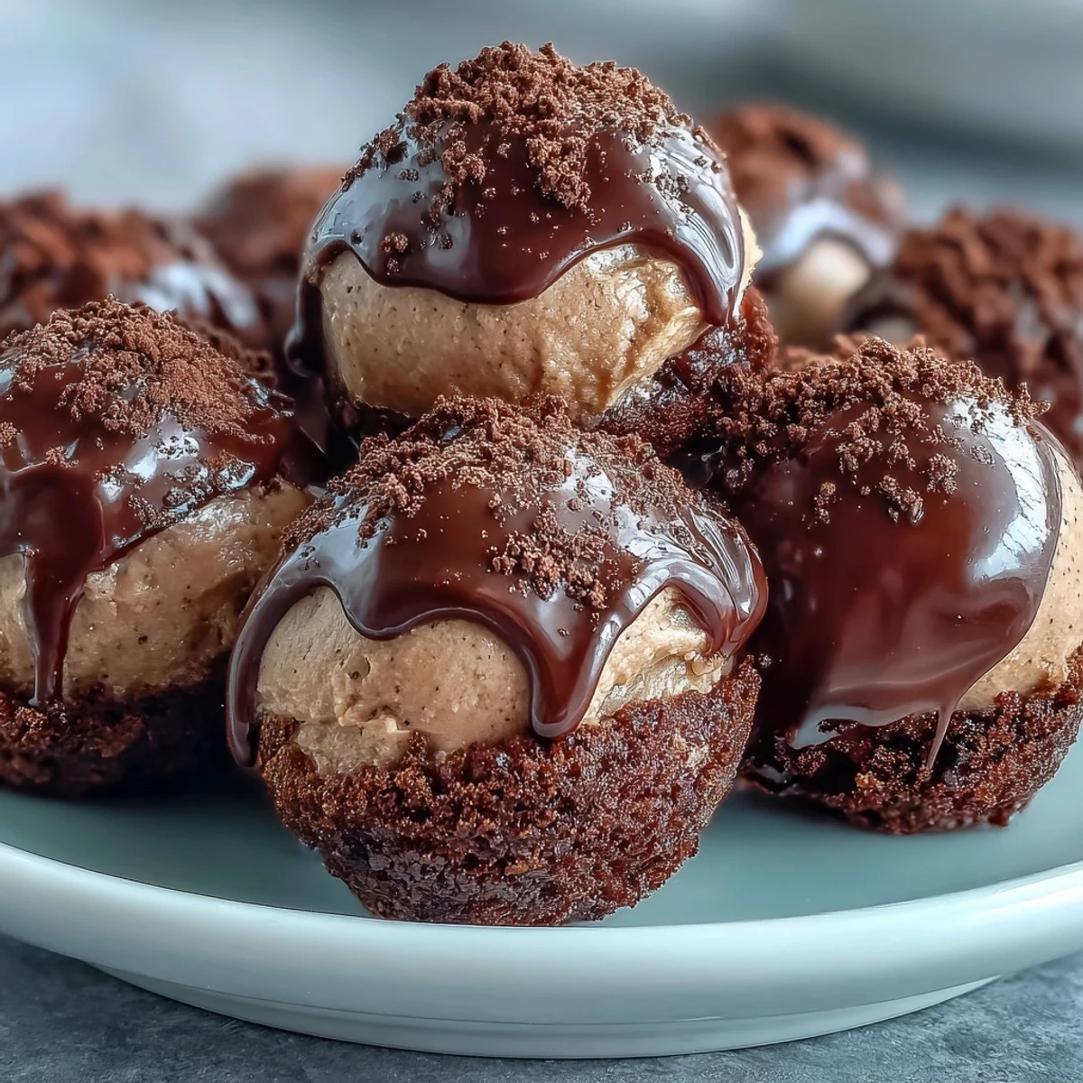 Four glossy Hojicha Truffles on a white plate, with a warm cup of hojicha beside them.