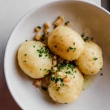 Close up view of golden potato dumplings glistening with truffle oil, ready to serve.