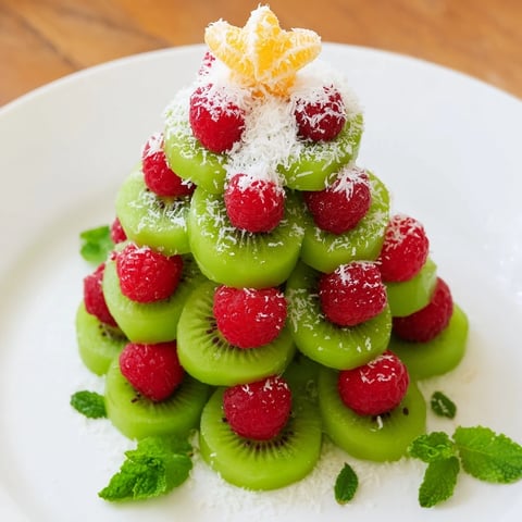 Festive Kiwi and Raspberry Christmas tree fruit plate, a healthy holiday snack bursting with fresh, vibrant flavors.