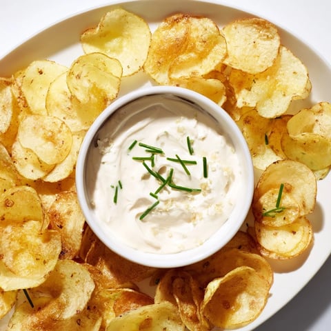 Crispy potato chips alongside a creamy onion dip, perfect for a flavorful snack.