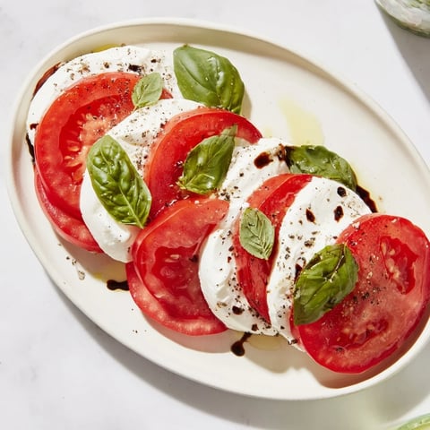 Sliced Tomatoes and Mozzarella Rounds, a colorful, simple Italian side dish with fresh basil.