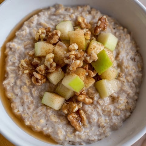 Creamy apple pie oatmeal bowl topped with warm, caramelized apples ready to eat for breakfast.