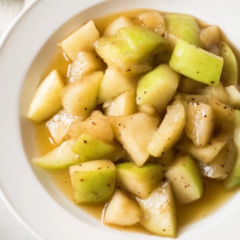Slow cooker stewed apples bubbling gently in a slow cooker, cinnamon-infused sweetness filling the kitchen.