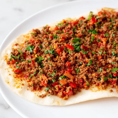 Knusprige türkische Lahmacun flambiert im Ofen, belegt mit aromatischem Hackfleisch und Gemüse.