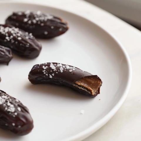 Rich dark chocolate-covered Chocolate Peanut Butter Dates, a perfect snack with flaky sea salt sprinkled on top.