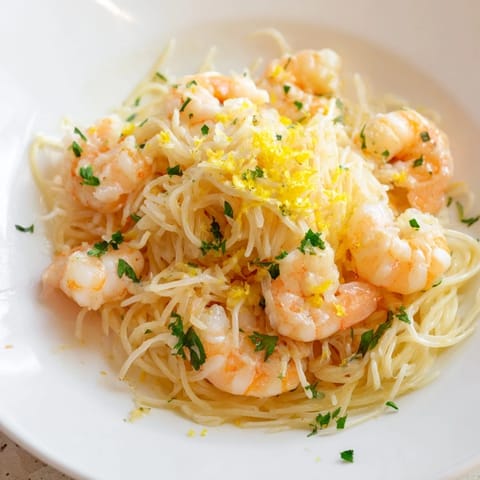 Goldene Lemon Butter Shrimp Pasta mit frischer Petersilie garniert.