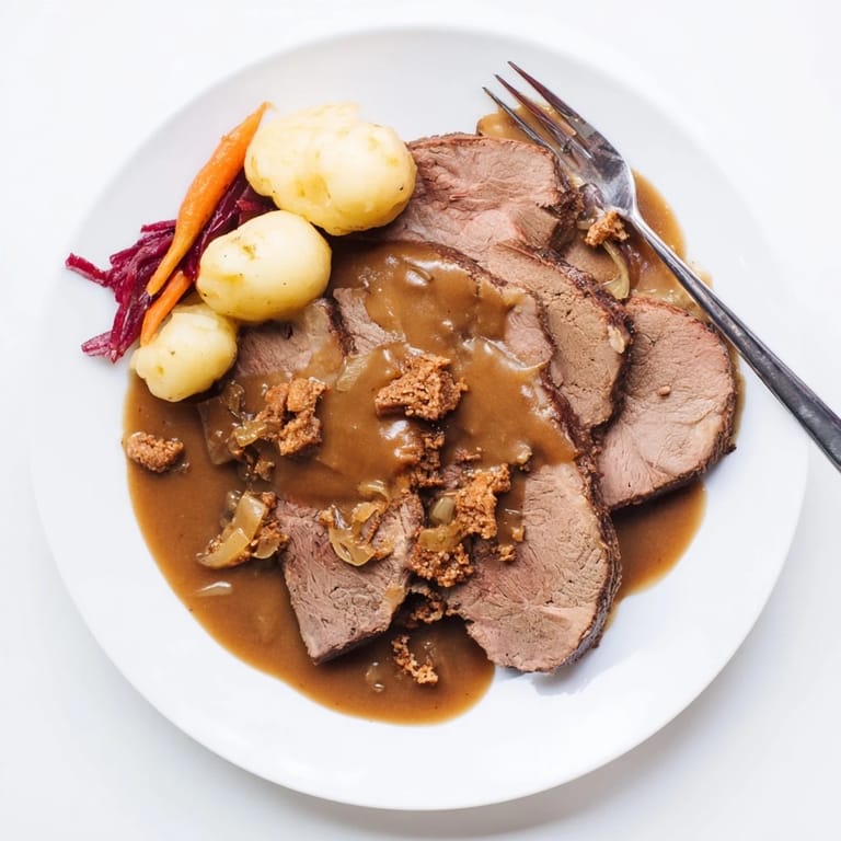 Traditioneller Sauerbraten, zartes Rindfleisch in reichhaltiger, süß-saurer Soße.  