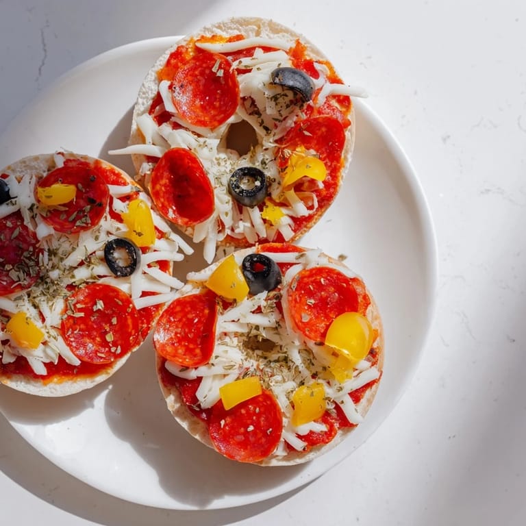 Close-up of melty mozzarella on mini bagel pizzas with pepperoni, ready to enjoy.