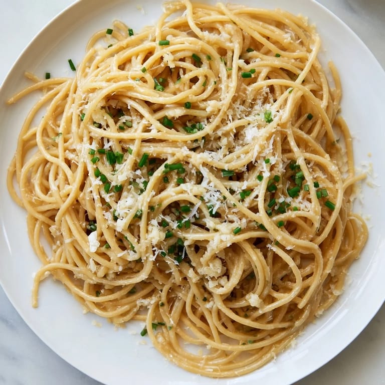 Close-up of savory Miso Butter Pasta, perfectly coated noodles with fresh chives.