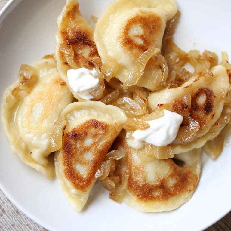 Tender, potato-filled Polish pierogi, pan-fried to golden perfection, ready to be served.